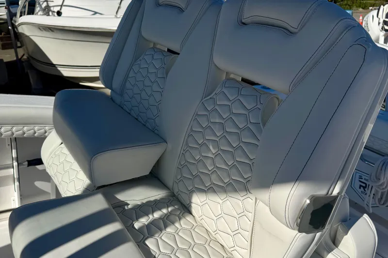 Slide: The Image of 2026 Tidewater 282 CC Adventure boat seats with hexagonal stitching and armrest. - 22