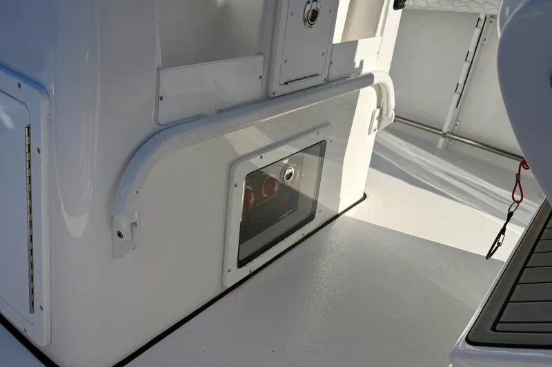 Slide: The Image of 2026 Tidewater 282 CC Adventure boat interior, featuring sleek white design and storage compartment. - 25