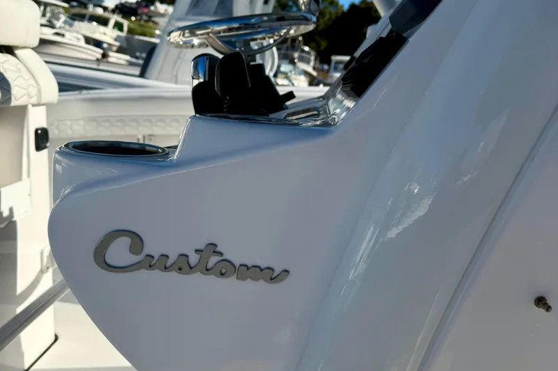 Slide: The Image of 2026 Tidewater 282 CC Adventure boat interior with "Custom" detail and cup holder. - 26