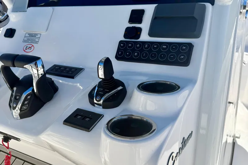 Slide: The Image of Control panel of 2026 Tidewater 282 CC Adventure boat with joystick and cup holders. - 27
