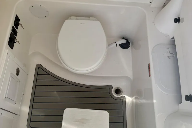 Slide: The Image of Interior of 2026 Tidewater 282 CC Adventure boat featuring a compact marine toilet. - 42