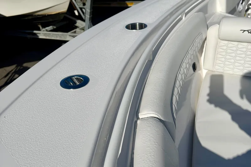 Slide: The Image of 2026 Tidewater 282 CC Adventure boat interior with white seating and cup holders. - 55