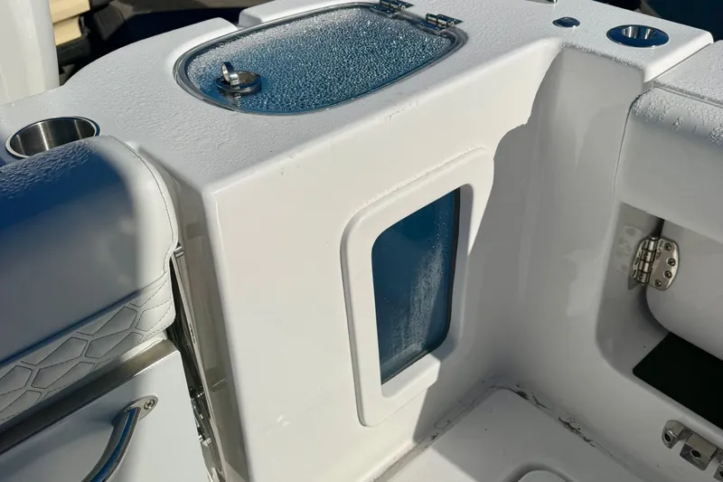 Slide: The Image of 2026 Tidewater 282 CC Adventure boat interior with storage compartment and cup holder. - 59