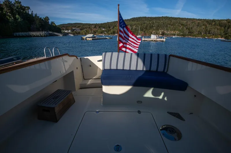 Slide: The Image of Hinckley Talaria 34 boat deck with American flag, scenic waterfront view, 2013 model. - 10