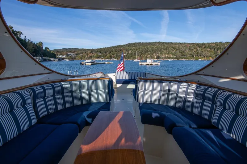 Slide: The Image of Luxurious 2013 Hinckley Talaria 34 yacht interior with striped seating, overlooking scenic waterfront. - 12