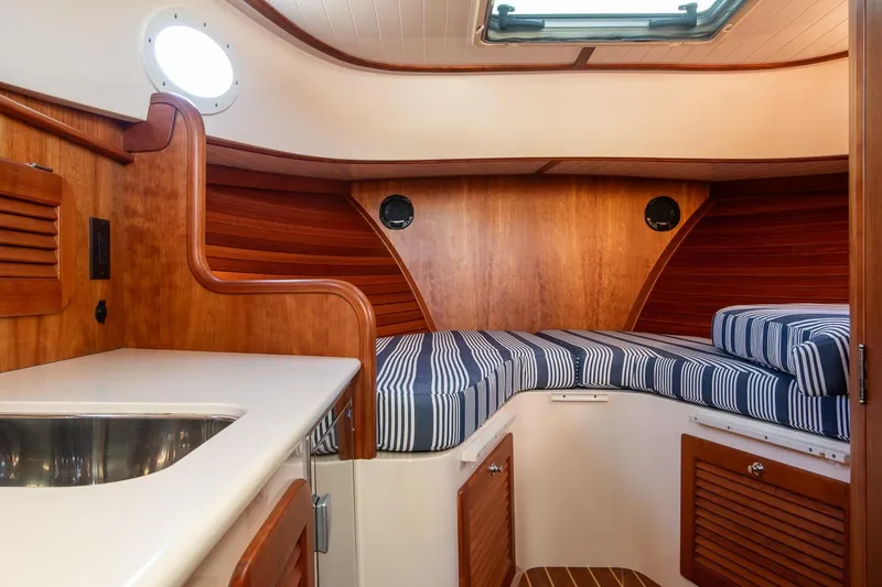 Slide: The Image of Interior of 2013 Hinckley Talaria 34 yacht with wood finish and striped cushions. - 19