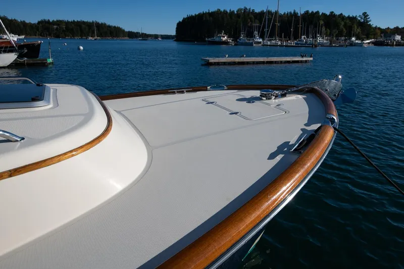 Slide: The Image of 2013 Hinckley Talaria 34 yacht deck with wooden trim, docked in a serene marina. - 8