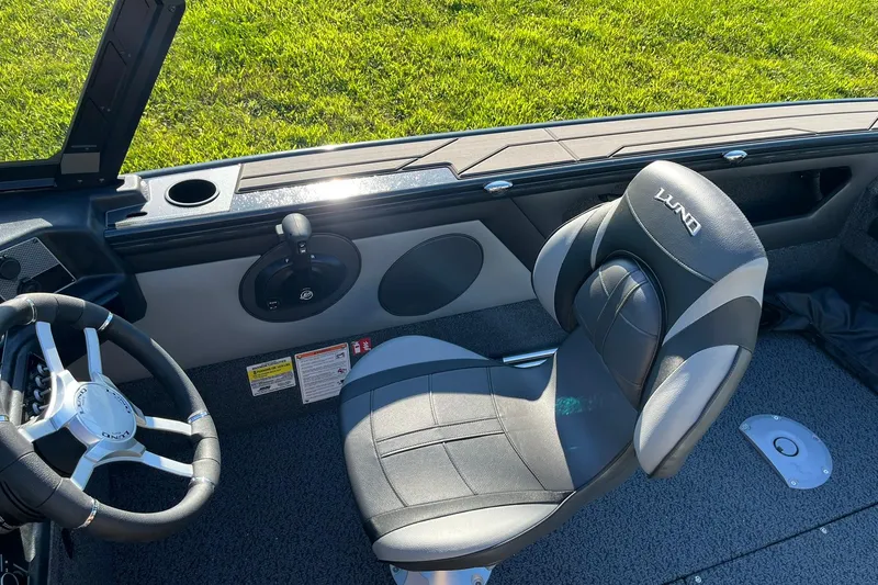 Slide: The Image of 2026 Lund 1875 Crossover XS boat storage compartment with net and yellow handle. - 10