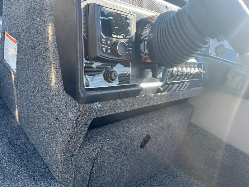 Slide: The Image of 2026 Lund 1875 Crossover XS boat interior with carpeted deck and storage compartments. - 16