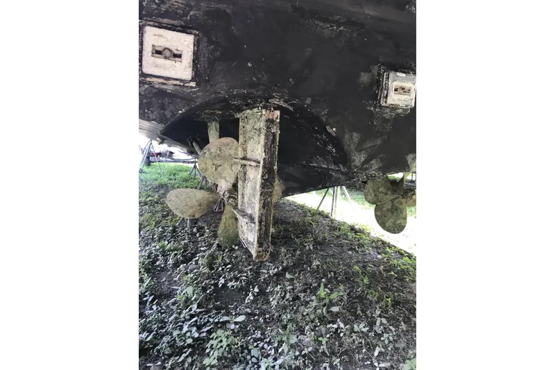 Slide: The Image of Underside of a 1999 Custom Sport Fishing boat with visible propellers and rudder. - 15