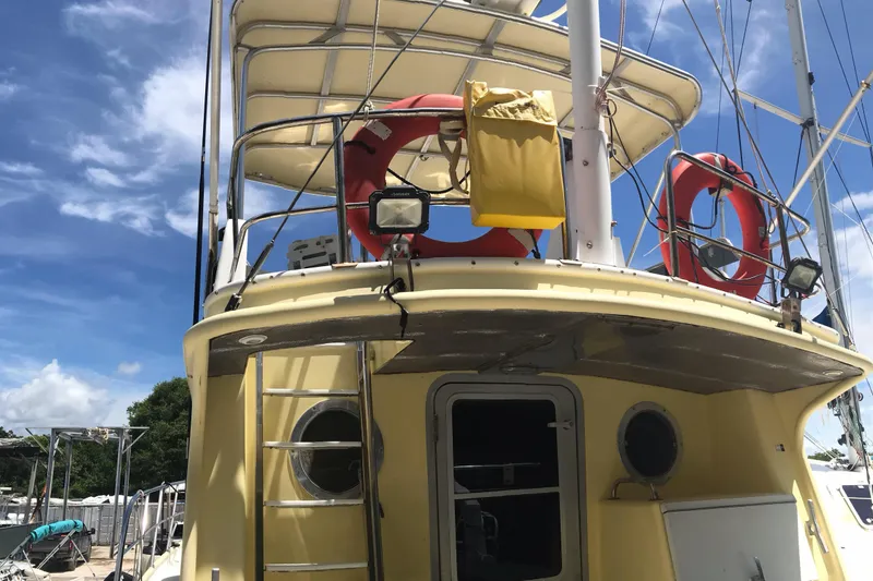 Slide: The Image of 1999 Custom Sport Fishing boat with life rings and ladder under a clear sky. - 22