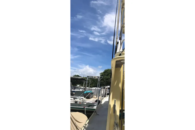 Slide: The Image of Custom 1999 Sport Fishing boat docked under a clear blue sky. - 24