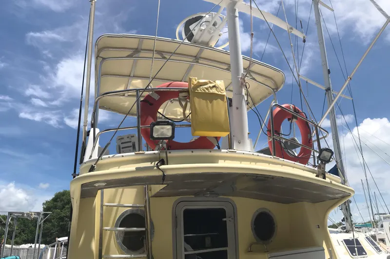 Slide: The Image of 1999 Custom Sport Fishing boat with life rings and equipment under a clear blue sky. - 25