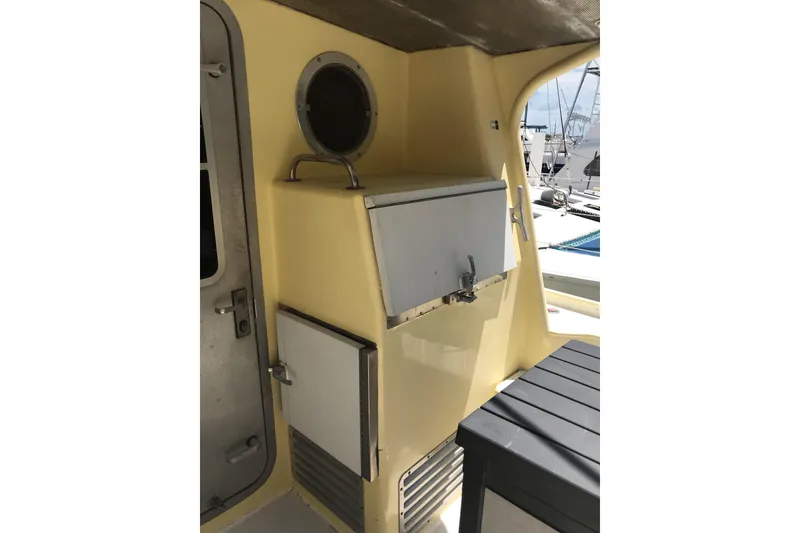 Slide: The Image of 1999 Custom Sport Fishing boat interior with storage compartments and porthole. - 26