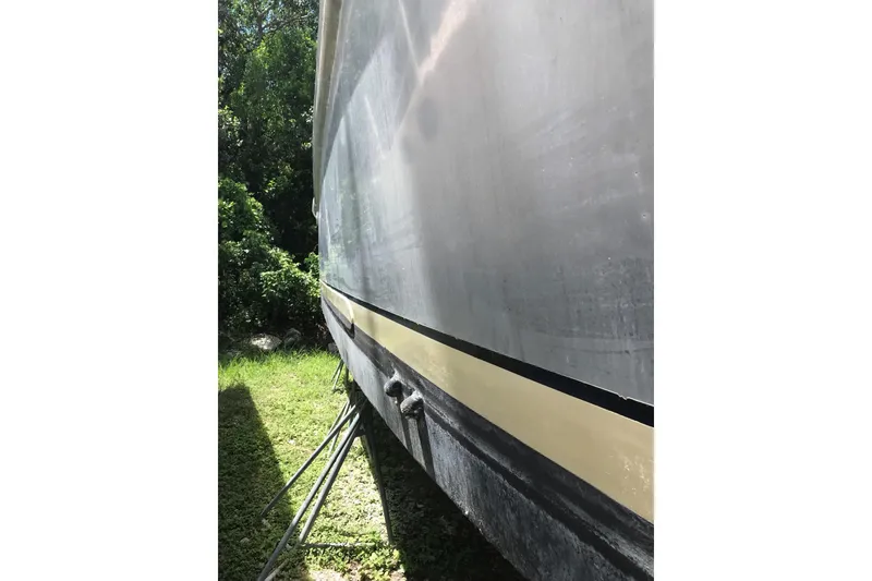 Slide: The Image of Side view of a 1999 Custom Sport Fishing boat on land, surrounded by greenery. - 3