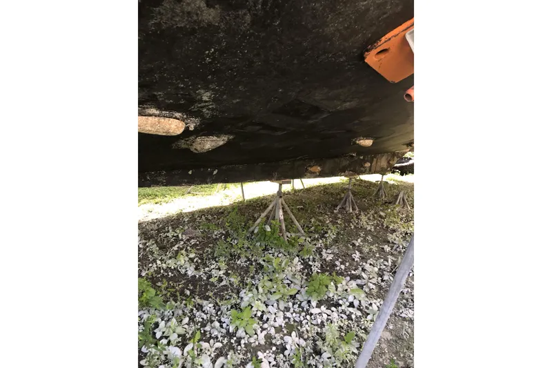 Slide: The Image of Underside of a 1999 Custom Sport Fishing boat on stands, showing hull details. - 34