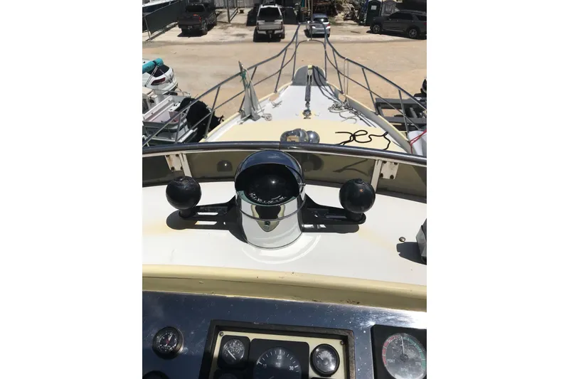 Slide: The Image of 1999 Custom Sport Fishing boat helm with compass and controls, docked in a marina. - 43