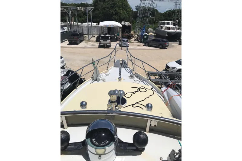 Slide: The Image of 1999 Custom Sport Fishing boat in a marina, surrounded by vehicles and other boats. - 44