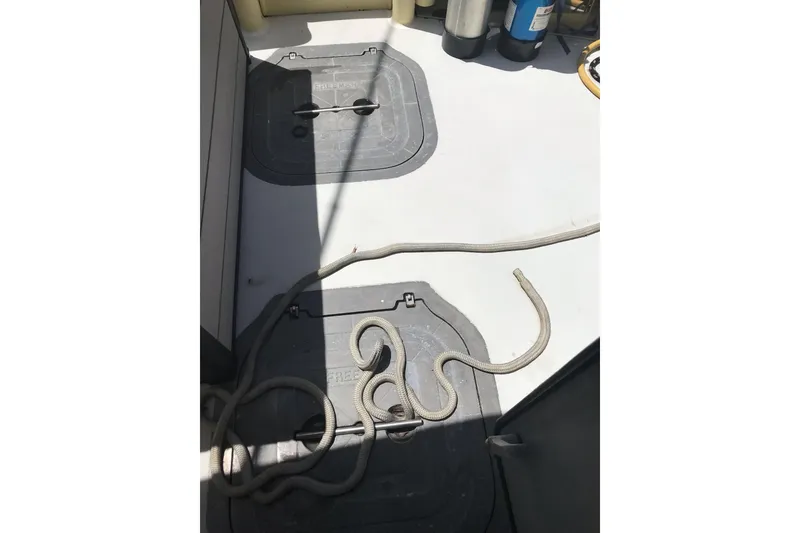 Slide: The Image of Deck of 1999 Custom Sport Fishing boat with ropes and storage hatches. - 46