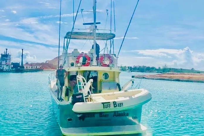 Slide: The Image of Custom 1999 sport fishing boat on clear blue water, docked near shore. - 58