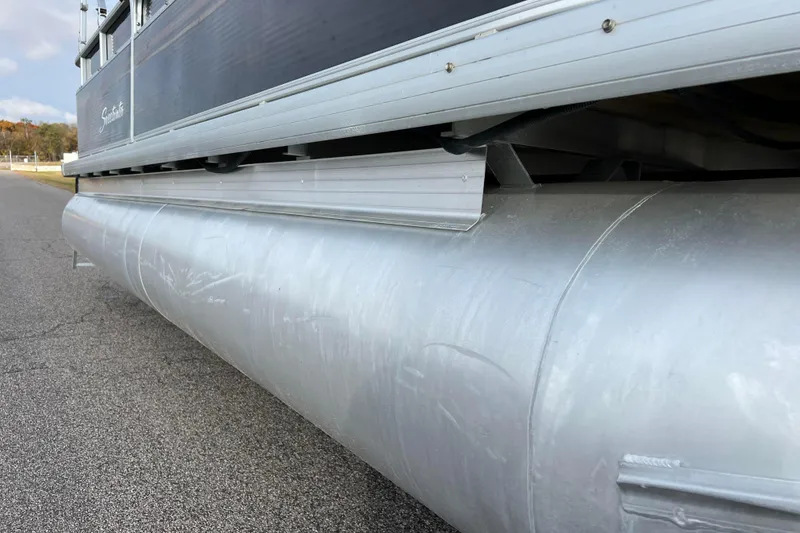 Slide: The Image of 2013 Godfrey Sweetwater 2286 pontoon boat, side view of aluminum pontoon on pavement. - 13