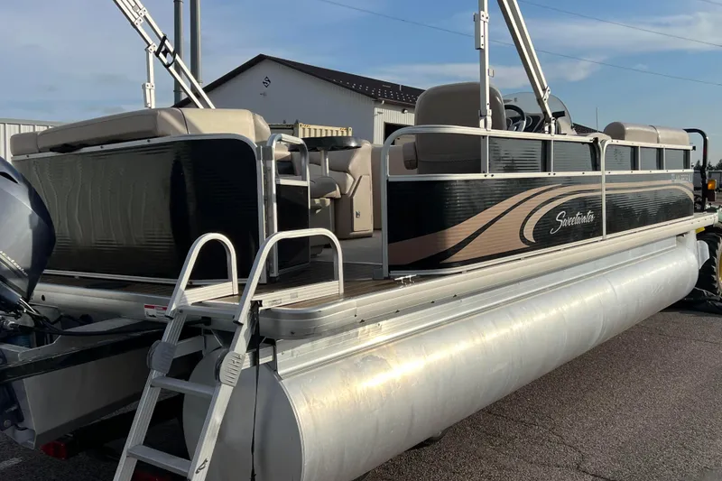 Slide: The Image of 2013 Godfrey Sweetwater 2286 pontoon boat with ladder and seating, parked outdoors. - 2