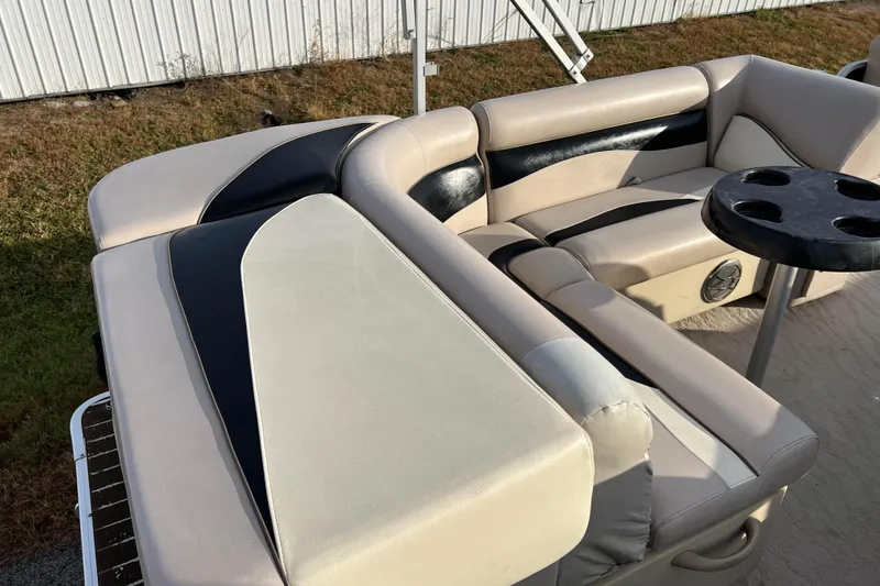 Slide: The Image of 2013 Godfrey Sweetwater 2286 boat interior with beige and black seating, cup holders. - 25