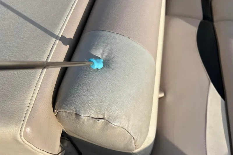 Slide: The Image of Close-up of a 2013 Godfrey Sweetwater 2286 boat seat with a blue tool. - 48