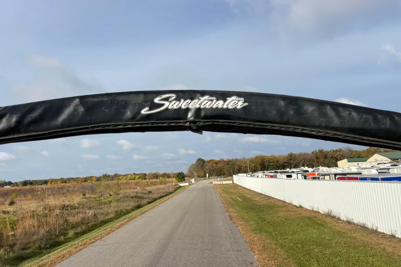 Slide: The Image of 2013 Godfrey Sweetwater 2286 boat cover on a rural road with clear skies. - 54