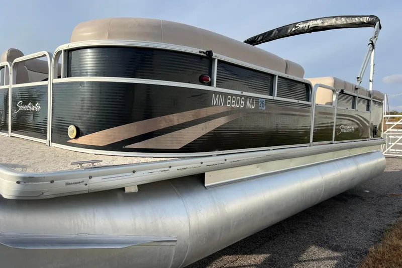 Slide: The Image of 2013 Godfrey Sweetwater 2286 pontoon boat with sleek design and beige seating. - 6
