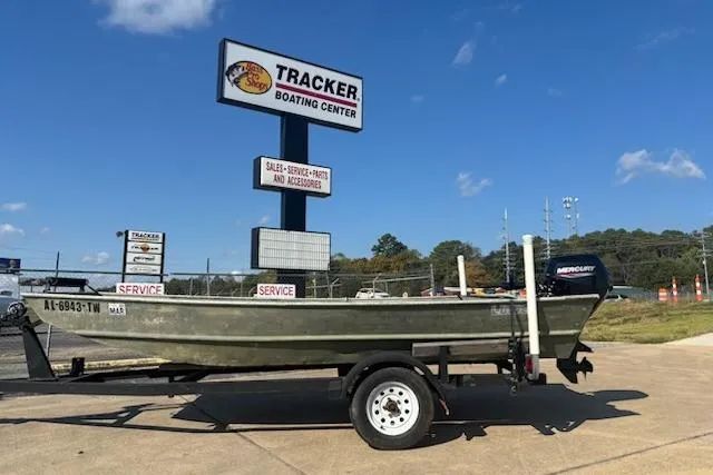 Slide: The Image of 1981 Lowe L1448 Jon boat on trailer at Tracker Boating Center under clear blue sky. - 1