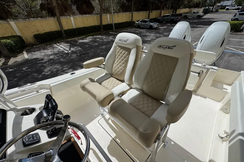 Slide: The Image of 2026 Bulls Bay 255CC boat interior with dual cushioned seats and steering console. - 16