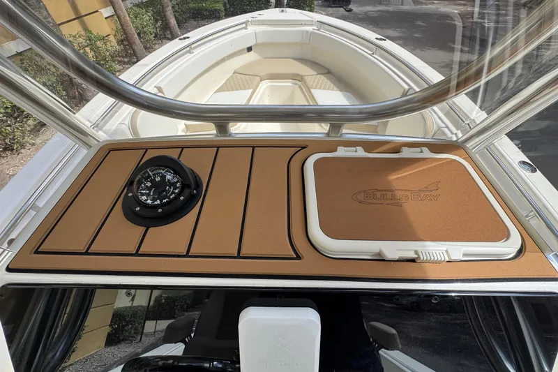 Slide: The Image of 2026 Bulls Bay 255CC boat dashboard with compass and storage compartment. - 18