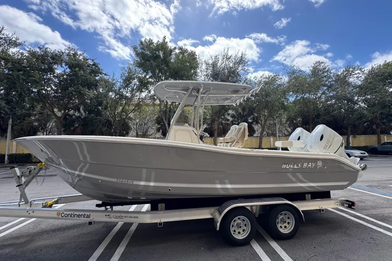 Slide: The Image of 2026 Bulls Bay 255CC boat on trailer, parked outdoors under a partly cloudy sky. - 4