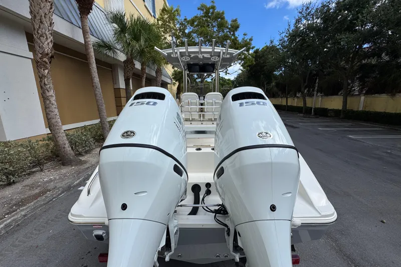 Slide: The Image of 2026 Bulls Bay 255CC boat with dual 150 horsepower engines, parked outdoors. - 5