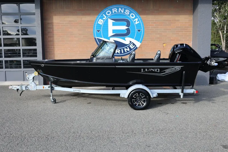 The Image of 2026 Lund 1800 Explorer Sport boat on trailer at Bjornson Marine dealership. - 1