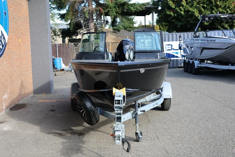 Slide: The Image of 2026 Lund 1800 Explorer Sport boat on trailer, parked outdoors. - 11