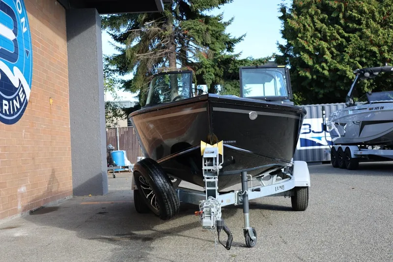 Slide: The Image of 2026 Lund 1800 Explorer Sport boat on trailer outside marine shop. - 12