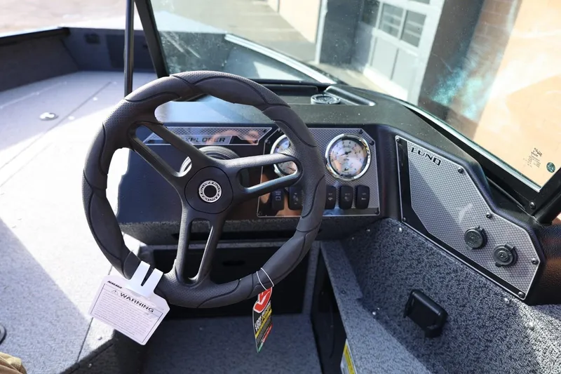 Slide: The Image of 2026 Lund 1800 Explorer Sport boat dashboard with steering wheel and gauges. - 30