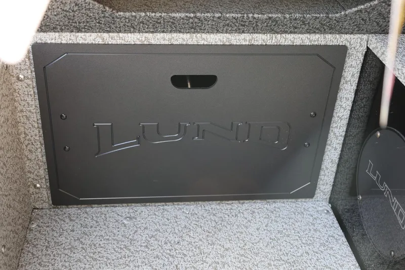Slide: The Image of Interior storage compartment of 2026 Lund 1800 Explorer Sport boat, featuring carpeted finish. - 33