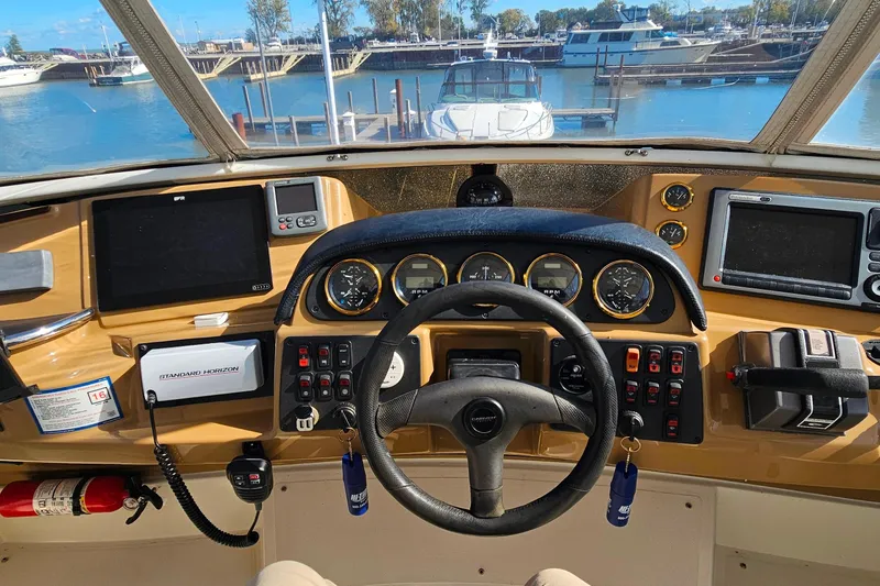 Slide: The Image of 2004 Carver 444 Cockpit Motor Yacht helm with navigation instruments and steering wheel. - 16