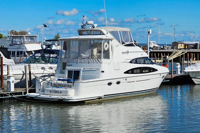 Slide: The Image of 2004 Carver 444 Cockpit Motor Yacht docked at marina under blue sky. - 2