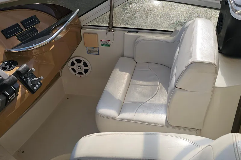Slide: The Image of Interior of 2004 Carver 444 Cockpit Motor Yacht with white seating and control panel. - 24