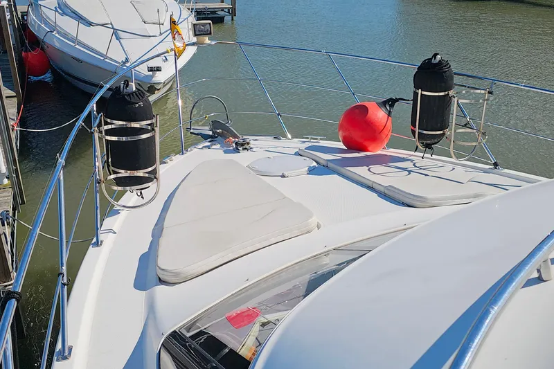 Slide: The Image of 2004 Carver 444 Cockpit Motor Yacht docked, featuring spacious deck and safety equipment. - 27