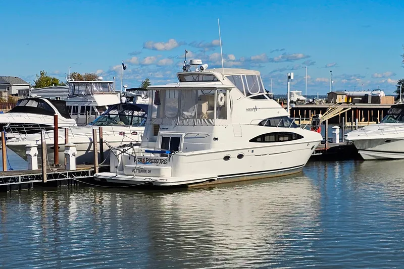 Slide: The Image of 2004 Carver 444 Cockpit Motor Yacht docked at a marina under a clear blue sky. - 3