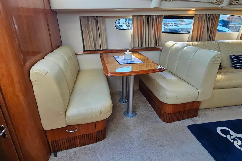 Slide: The Image of 2004 Carver 444 Cockpit Motor Yacht interior with beige seating and wooden table. - 36