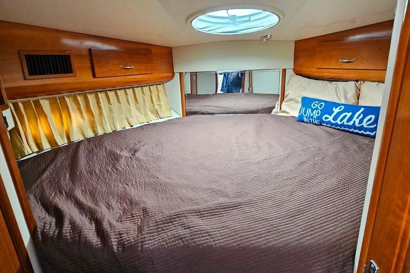 Slide: The Image of Cozy bedroom in 2004 Carver 444 Cockpit Motor Yacht with brown bedding and decorative pillow. - 39