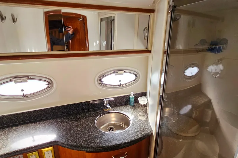 Slide: The Image of 2004 Carver 444 Cockpit Motor Yacht bathroom with sink, mirror, and shower. - 49