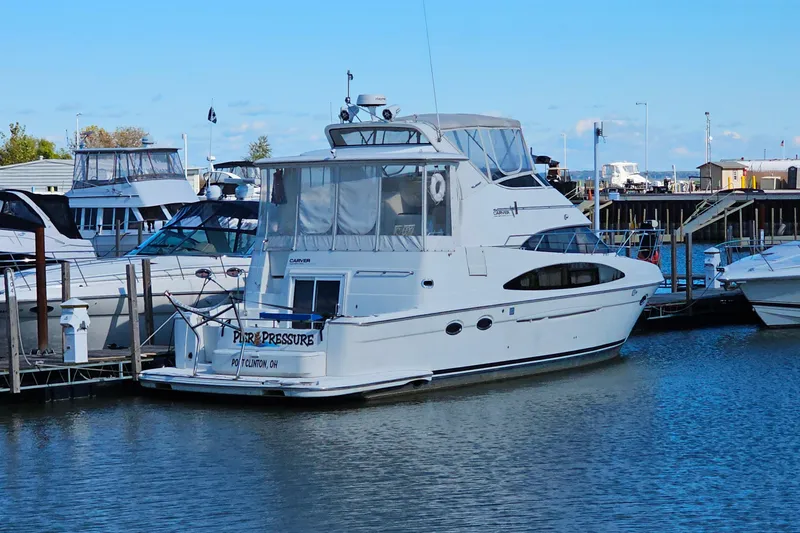 Slide: The Image of 2004 Carver 444 Cockpit Motor Yacht docked in a marina, clear blue sky. - 53