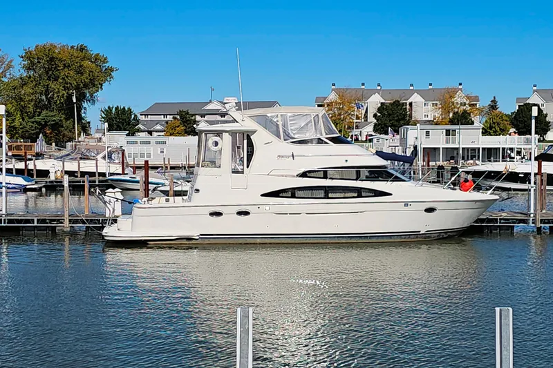 Slide: The Image of 2004 Carver 444 Cockpit Motor Yacht docked in a marina under clear blue skies. - 54